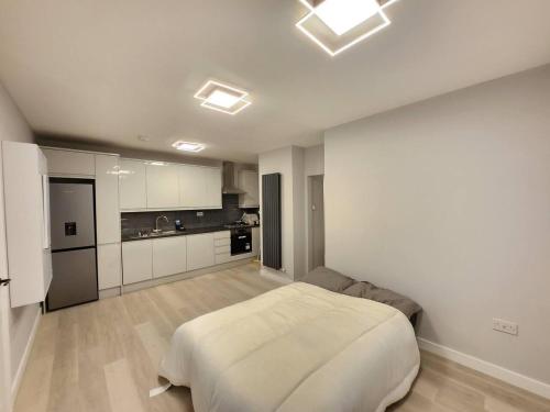 a bedroom with a white bed and a kitchen at Beautiful 2-Bed Apartment in London - Sleeps 6! in London