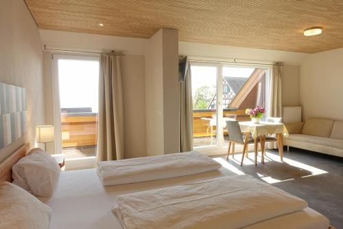 2 Betten in einem Zimmer mit einem Tisch und einem Zimmer mit einem Tisch in der Unterkunft Gästehaus Hornstein in Nonnenhorn