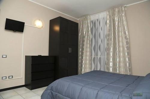 a bedroom with a blue bed and a black cabinet at Albergo Aurora in Grignasco