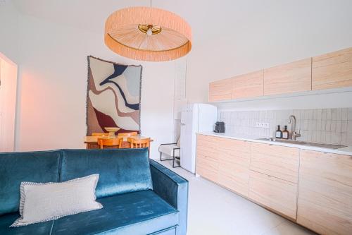 - une cuisine avec un canapé bleu dans une chambre dans l'établissement NOCNOC - Le Ceramica - Le calme en ville, T3 très fonctionnel, à Montpellier
