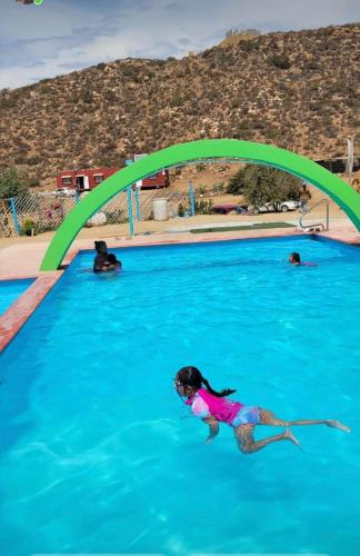 a little girl swimming in a swimming pool at Cabaña en Rancho los reyes in Tijuana