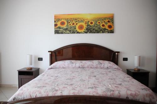1 dormitorio con 1 cama y una pintura de girasoles en Il Girasole - Apartment, en Avezzano