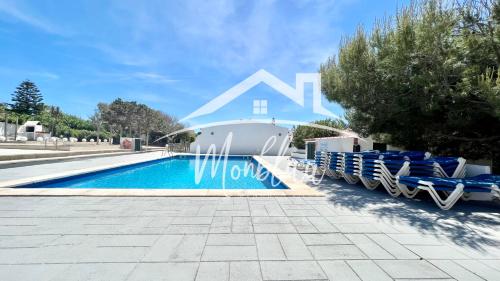 a villa with a swimming pool and lounge chairs at MiRADOR DEL FARO in Cala en Bosc