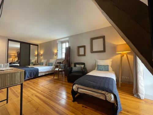 une chambre d'hôtel avec deux lits et une chaise dans l'établissement Coté jardin, à Sainte-Suzanne
