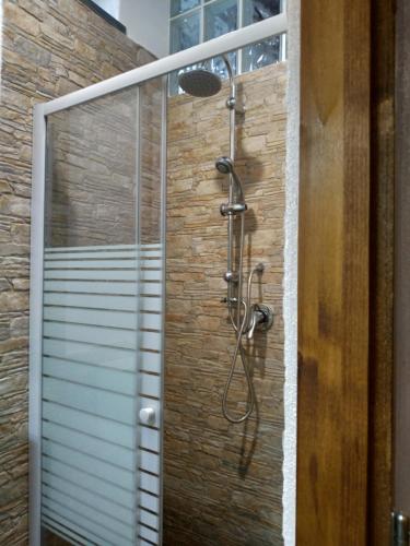een douche in een badkamer met een bakstenen muur bij perla spiaggia in Leni