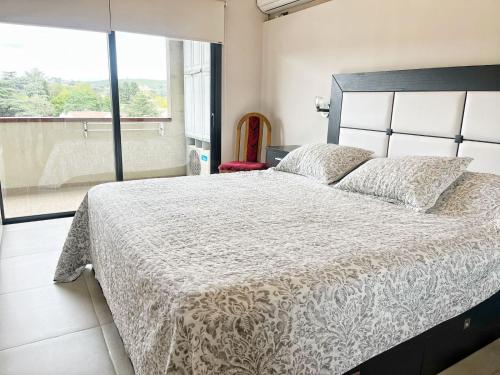1 dormitorio con cama grande y ventana grande en Constantino IV en Villa Carlos Paz