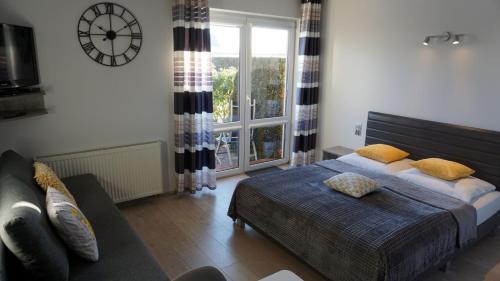 a bedroom with a bed and a clock on the wall at Willa Klif in Rowy