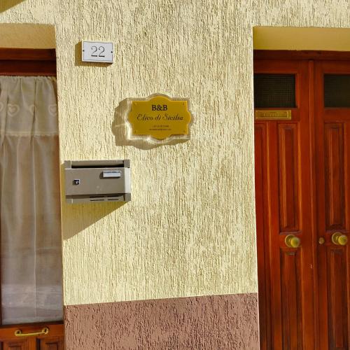 a sign on the side of a building with a door at Elico Di Sicily B@B in Sambuca di Sicilia
