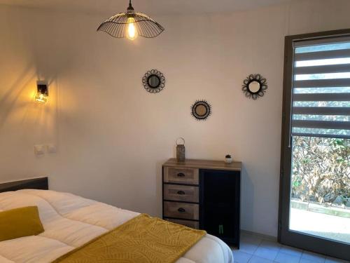 um quarto com uma cama, uma janela e uma cómoda em La Geck'home em Le Barcarès