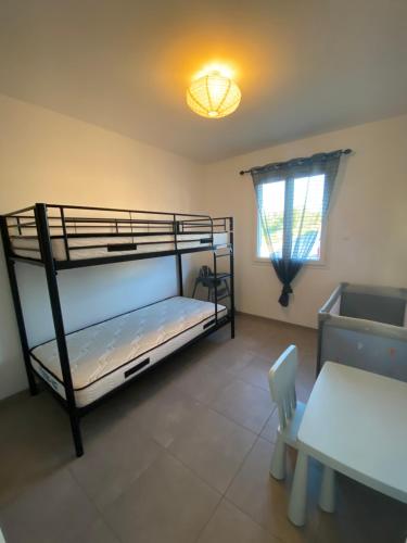 - une chambre avec 2 lits superposés et une table dans l'établissement Vacances Vallée de la Dordogne, à Souillac