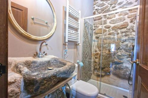 y baño con ducha de piedra y lavamanos. en casa rural La Cuadra, en Villar de Corneja