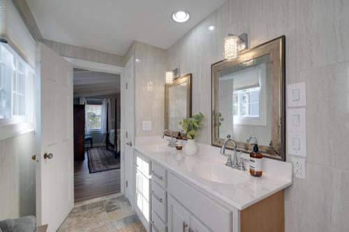 a white bathroom with a sink and a mirror at Historic Downtown Gem - Walk to Everything! in Fredericksburg