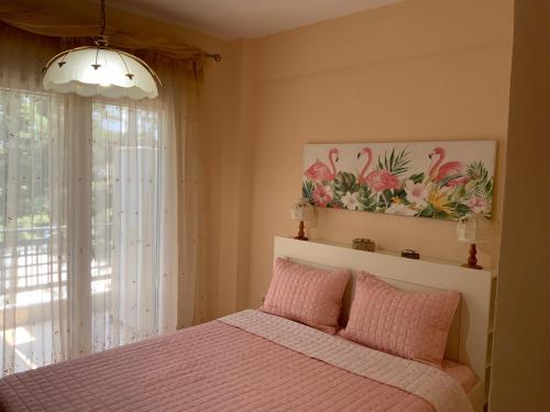 a bedroom with a pink bed and a window at Alexandra's House Nea Fokaia in Nea Fokea