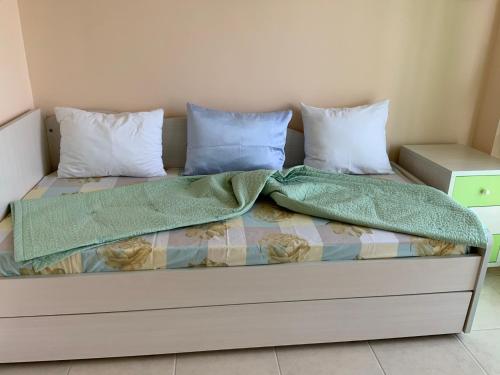a bed with two pillows and two blankets at Alexandra's House Nea Fokaia in Nea Fokea