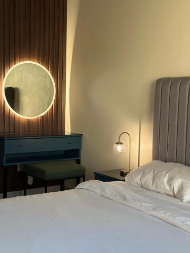 a bedroom with a bed and a mirror and a chair at شاليهات كابري وماديرا درة العروس in Durat Alarous