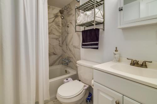 Un baño blanco con inodoro y lavabo. en Pet-Friendly Pocono Lake Home with Fire Pit and Deck!, en Pocono Lake