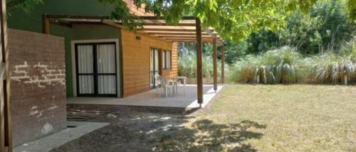 a house with a patio with a table in a yard at Suite de campo in Chascomús