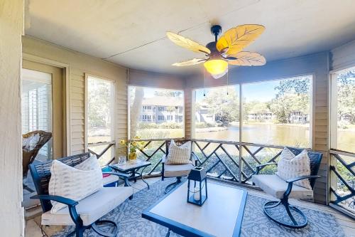 a porch with chairs and a butterfly ceiling fan at Turtle Cove 4839 in Kiawah Island