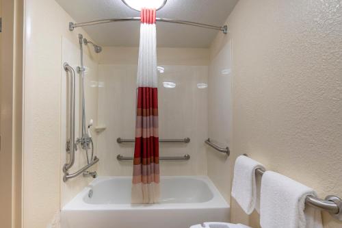 a bathroom with a shower and a tub and a sink at Red Roof Inn PLUS+ Houston - Energy Corridor in Houston