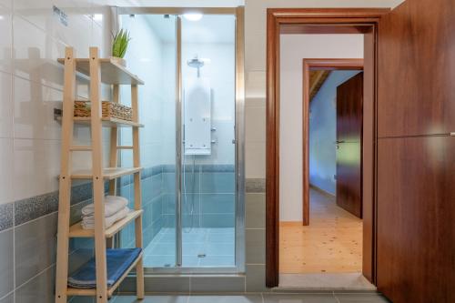 y baño con ducha de cristal y escalera de madera. en Crystal Beach Villa en Chalkida