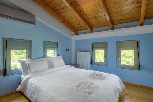 a bedroom with a white bed with two towels on it at Crystal Beach Villa in Chalkida
