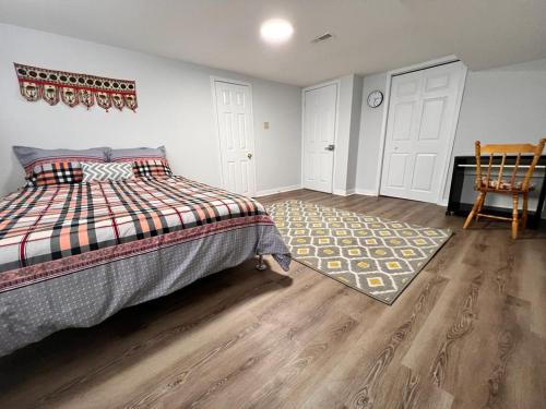 um quarto com uma cama, um tapete e uma cadeira em Cozy basement 2 bedroom 2 bath with parking em Richmond Hill