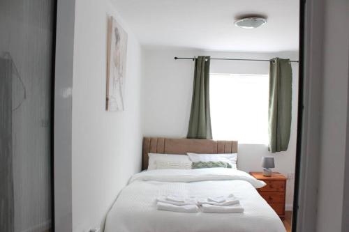 a bedroom with a bed with two white towels on it at Self-contained guest suite in Eltham