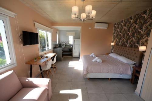 1 dormitorio con cama, sofá y mesa en La Morada Apart Boutique en Villa Gesell