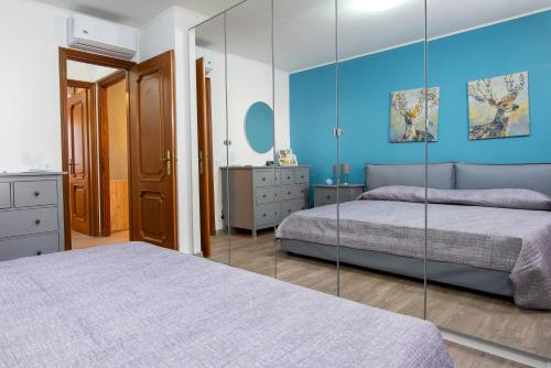 a bedroom with two beds and a mirror at Casa del Sole: Relax & Charme nella Riviera Ligure in Camporosso