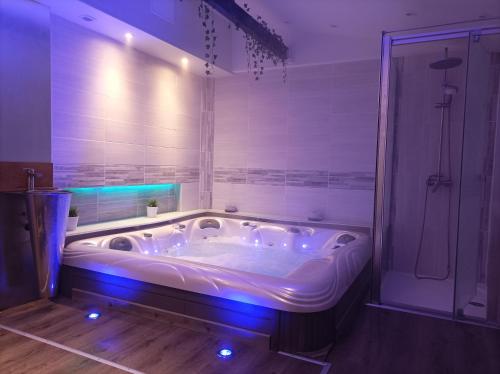 a large bath tub with blue lights in a bathroom at Les Charmois in Bains-les-Bains