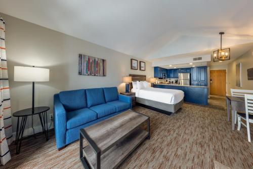 um quarto de hotel com uma cama e um sofá azul em Raintree's Park Plaza Park City em Park City