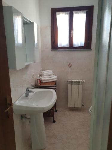łazienka z umywalką, toaletą i oknem w obiekcie Mare Fuori Lacona w mieście Capoliveri