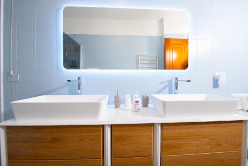 a bathroom with two sinks and a mirror at Casa del Sole: Relax & Charme nella Riviera Ligure in Camporosso