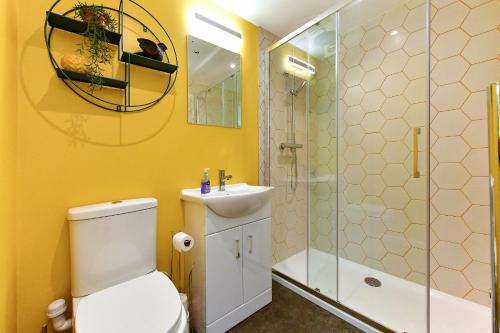 uma casa de banho com um WC, um lavatório e um chuveiro em Dan Y Coed em Pont-Nedd-Fechan