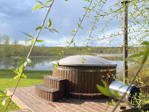 une grande baignoire en bois installée sur une terrasse en bois à côté d'un lac dans l'établissement PINCIKAJAS Holiday Home, 
