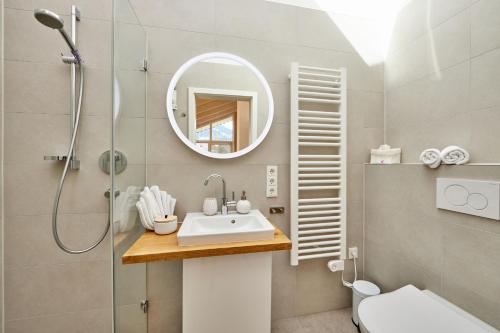 La salle de bains est pourvue d'un lavabo, d'une douche et d'un miroir. dans l'établissement Lichtblick, à Garmisch-Partenkirchen
