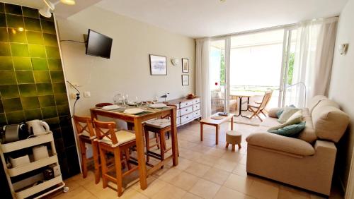 uma sala de estar com uma mesa e um sofá em Acogedor apartamento en l'Estartit con piscina y Parking em L'Estartit