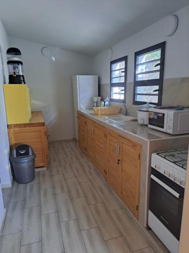 a kitchen with wooden cabinets and a white refrigerator at le tamarin in Toliara