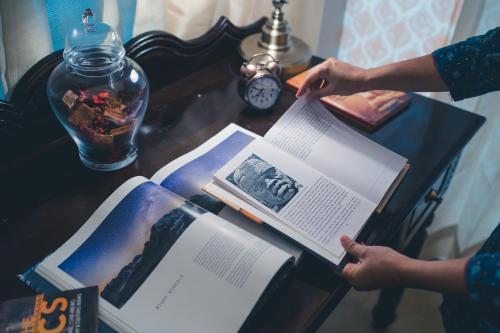 a person is reading a book on a table at Angirasa Luxury Camping in Hyderabad