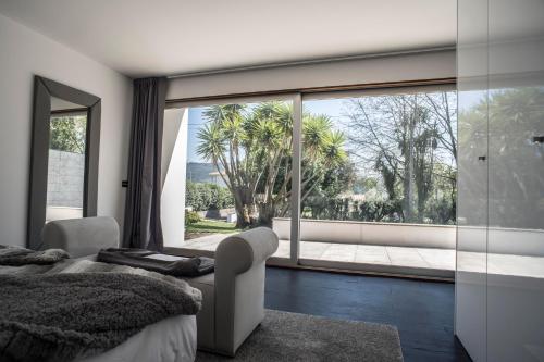a bedroom with a bed and a large window at Quinta Do Pomar Pomar Farm in Linhares