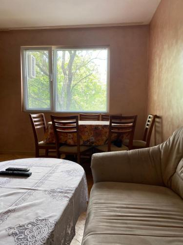 ルセにあるАПАРТАМЕНТ МИДИЯ ЕНОС РУСЕのテーブルと椅子、窓が備わる客室です。