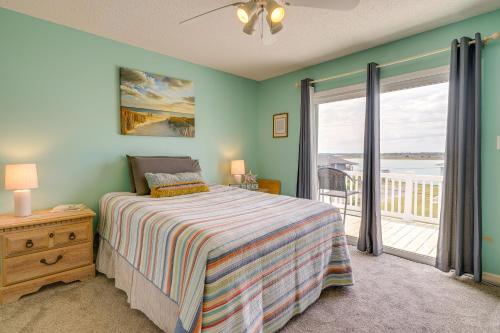 a bedroom with a bed and a balcony at Topsail Beach Vacation Rental Steps to Shore! in Topsail Beach