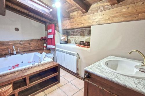 y baño con bañera y lavamanos. en La Cantina casas rurales paredes en Villar de Corneja
