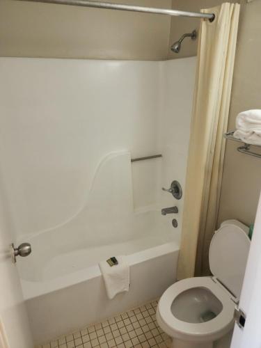 a bathroom with a white tub and a toilet at American Inn Chesapeake - Portsmouth in Chesapeake