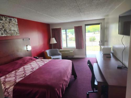 a hotel room with a bed and a desk at American Inn Chesapeake - Portsmouth in Chesapeake
