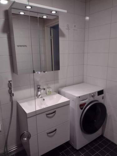 uma casa de banho com uma máquina de lavar roupa e um lavatório em New apparment near of Airport, in Tikkurila em Vantaa