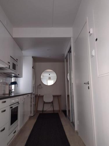 Cette chambre comprend une petite cuisine avec une chaise. dans l'établissement New apparment near of Airport, in Tikkurila, à Vantaa