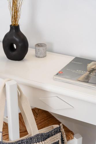 a white desk with a book and a vase on it at Erato Inn Naxos in Agios Prokopios