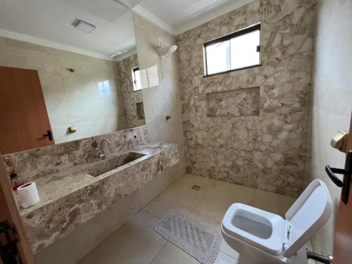 a bathroom with a tub and a toilet and a sink at Casa Malta - St Sul in Goiânia