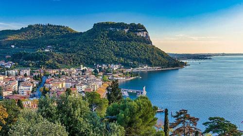 a small town on a hill next to a body of water at Residence Gli Ulivi in Castion Veronese